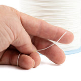 Hand holding a spool of white dyneema cord with a close-up view